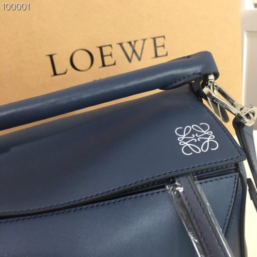 LOEWE 'Puzzle' Shoulder Bag. Original Quality Bag including gift box, care book, dust bag, authenticity card. The first completely new bag designed by Jonathan Anderson has become a LOEWE icon. With its innovative cuboid shape, extreme tactility and maximum utility, the volume is created through a precise cutting so the Puzzle bag can be worn in five different ways, from shoulder bag to clutch and folds completely until it´s flat. Key features: expertly crafted from calfskin, black hand-painted edges, herringbone-patterned cotton-canvas lining, and two internal slip compartments, handy exterior zip back pocket, embossed anagram. Removable adjustable shoulder strap for the most comfortable length. | CRIS&COCO Authentic Quality bags and Accessories