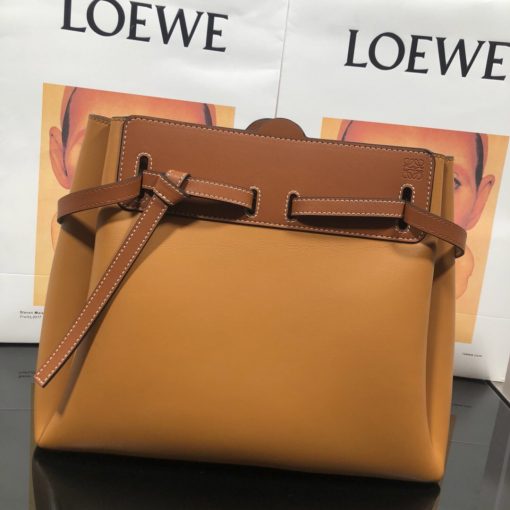 LOEWE Lazo Top Handle Bag. Authentic Quality Bag with literature, gift box, dust bag and authenticity card. A highly chic and sophisticated bag, the Lazo features the recognizable emblematic Gate knot. Contrasting calfskin straps holds the bag, cinching to fasten the bag effortlessly. Creating a sinuous accordion soft silhouette with soft natural calfskin, this novel interpretation is the next must-have chic functional bag of the season. The soft and slouchy calfskin bag is devoid of any zips for the closure and instead relies on the contrasting calfskin straps to cinch and fasten the opening. A relaxed update on a classic bag design. | CRIS&COCO Authentic Quality Designer Bags and Luxury Accessories
