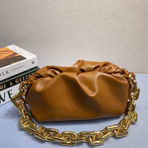 BOTTEGA VENETA The Chain Pouch. Original Quality Bag including gift box, literature, dust bag, authenticity card. BOTTEGA VENETA updates its cult Pouch bag with a chunky golden chain handle – a detail seen throughout the runway show. Crafted from supple Nappa leather in wear-with-anything shades, its magnetic frame is covered in voluminous folds that echo the brand's modern interpretation of its heritage. |CRIS AND COCO Authentic Quality Designer Bags and Luxury Accessories