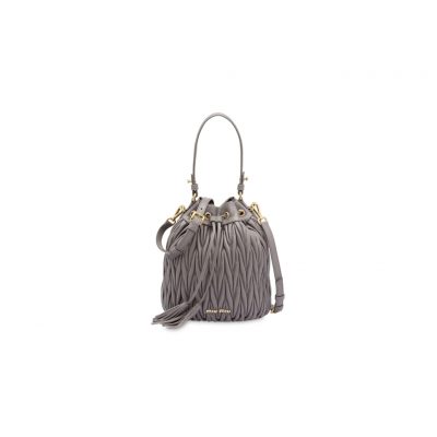 MIU MIU Matelassé Drawstring Bucket Bag. Original Quality Bag including gift box, care book, dust bag, authenticity card. Known as PRADA’s ‘little sister label’, MIU MIU harnesses the same high quality and luxury, while introducing a playful, girlish charm to the mix. This Nappa leather matelassé drawstring bucket bag from MIU MIU will keep your valuables safe in style. Featuring gold-tone hardware, a top handle, a detachable and adjustable shoulder strap, a matelassé texture, a lettered logo plaque to the front, a drawstring fastening, an internal slip pocket, and an internal logo plaque. | CRIS&COCO Original Quality Designer Bags and Luxury Accessories