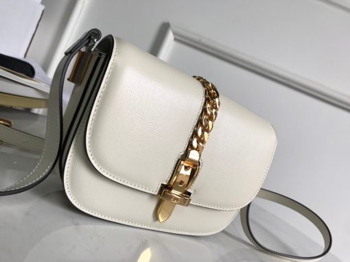 GUCCI Sylvie 1969 Mini Shoulder Bag. Original Quality Bag including gift box, care book, dust bag, authenticity card. Introduced in a mini size for Pre-Fall 2020, the Sylvie 1969 shoulder bag is designed with its original archetype in mind, unifying the details of its archival inspiration with a contemporary spirit. The shoulder bag in textured leather is defined by a narrow gold-toned metal chain fitted to the flap. The softly rounded silhouette is completed with an adjustable strap that can be worn on one shoulder or cross body. | Cris and Coco Original Quality Bags and Luxury Accessories
