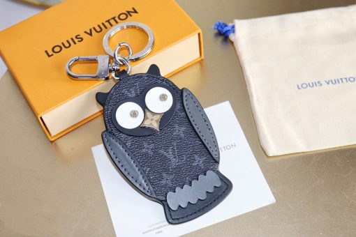 LOUIS VUITTON Owl Bag-Charm & Key Holder. Original Quality Charm including gift box, care book, dust bag, authenticity card. The mascot on the Owl bag charm and key holder is brought to life with LV studs for eyes and a Monogram Flower beak. Gold-color hardware joins calf leather and Monogram Eclipse canvas in a playful mingling of the House's signature materials. The hook and ring on this are both engraved with the Louis Vuitton signature for an elegant finish. | CRIS&COCO Authentic Quality Designer Bags and Luxury Accessories