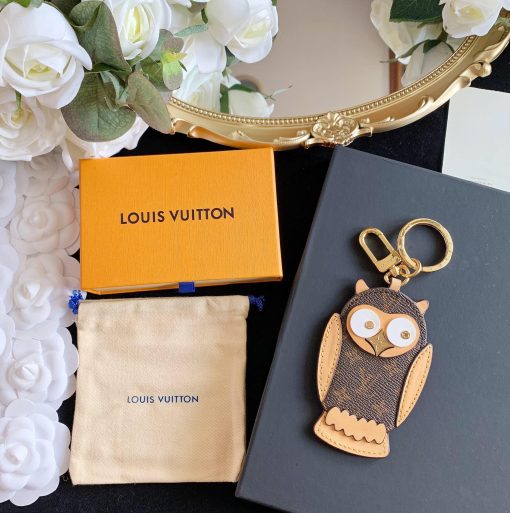 LOUIS VUITTON Owl Bag-Charm & Key Holder. Original Quality Charm including gift box, care book, dust bag, authenticity card. The mascot on the Owl bag charm and key holder is brought to life with LV studs for eyes and a Monogram Flower beak. Gold-color hardware joins calf leather and Monogram Eclipse canvas in a playful mingling of the House's signature materials. The hook and ring on this are both engraved with the Louis Vuitton signature for an elegant finish. | CRIS&COCO Authentic Quality Designer Bags and Luxury Accessories