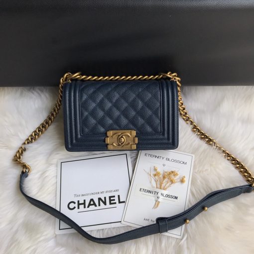 CHANEL Small Boy Handbag. Original Quality Bag including gift box, care book, dust bag, authenticity card. Even though the Boy was only introduced in 2011, the style has quickly achieved the status of an icon. Designed by Karl Lagerfeld and named after Boy Capel, the now legendary love of Coco Chanel’s life, the bag encapsulates masculine chic conveyed through rigid structure, boxy shape and sharp corners. This CHANEL Small Handbag is instantly recognizable for its simple, boxy silhouette and sharp corners, embellished only with a contrasting, bold-looking link chain strap which is the main feature of the bag. This most popular variations of the Chanel Boy are available in either caviar or lambskin. There are no external pockets and the sole adornment is the quilted fascia. | CRIS&COCO Authentic Quality Designer Bags and Luxury Accessories