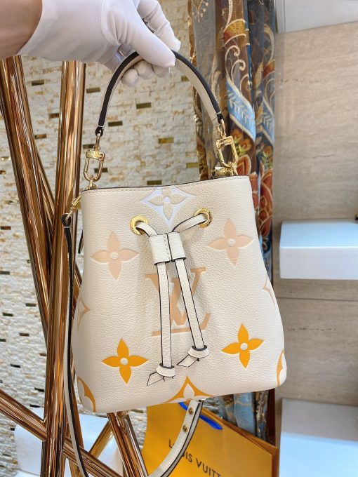 LOUIS VUITTON NéoNoé BB. Made from two-color Monogram Empreinte leather, the gradient pastel colorway of the Monogram Giant motif brings a festival feel to this resolutely on-trend NéoNoé BB bucket bag. It features a detachable top handle for hand and elbow carry as well as an adjustable strap for hand carry and over-the-shoulder wear. | CRIS&COCO Authentic Quality Designer Bags and Luxury Accessories
