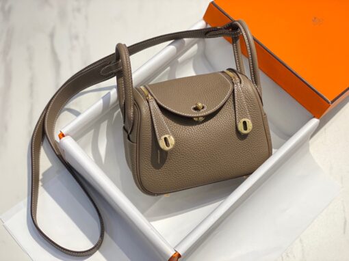 HERMÈS Mini Lindy. High-end quality bag including gift box, literature, dust bag, authenticity card. Maison HERMÈS is elevating the Lindy, with the introduction of the new Mini and is joining the holy Trinity, the Birkin, Kelly, and Constance.| CRIS AND COCO Authentic Quality Luxury Accessories