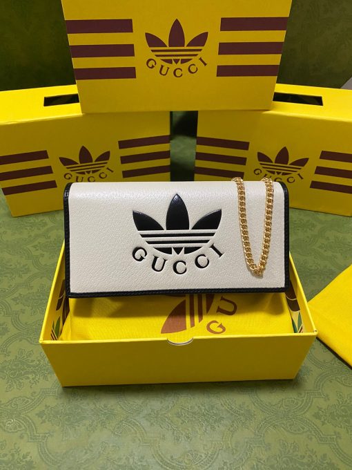 GUCCI X ADIDAS Wallet With Chain.  Original Quality Wallet including gift box, care book, dust bag, authenticity card. Part of the GUCCI X ADIDAS collection, this chain wallet features the Gucci Trefoil print. Emblematic House’s motifs mix with those of the historic sportswear brand adidas. The collection sees both heritages encoded in a trio of lines, where adidas and Gucci combine archival emblems. Creative Director, Alessandro Michele pulls inspiration from his memories of the ‘80s and ‘90s for a collection that is both nostalgia-driven and contemporary. | CRIS&COCO Authentic Quality Designer Bag and Luxury Accessories
