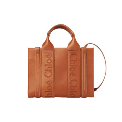 CHLOÉ Woody Tote Bag.  Original Quality Bag including gift box, care book, dust bag, authenticity card. Crafted from smooth calfskin for a natural look with a unique, luxurious feel, this Woody tote bag is a soft day-to-evening bag with a long, removable strap in addition to the top handles. The roomy inside compartment includes a practical flat pocket in leather for an elevated touch. Linen lining matches a refined finish with a lower environmental impact. The Woody line is characterised by the signature Chloé logo carried over from the Maison's iconic mules. It showcases a modern, minimalist silhouette. | CRIS&COCO Authentic Quality Designer Bag and Luxury Accessories