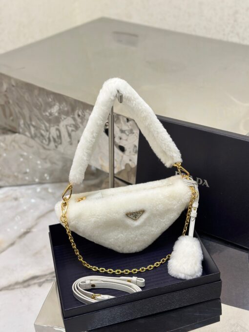 PRADA Shearling Mini Bag. Original Quality Bag including gift box, care book, dust bag, authenticity card. The softness and fuzziness of shearling accentuate the modern, wintry allure of this mini-bag characterized by its harmonious and delicate shape. The bag accented with a chain handle is decorated with the enameled metal triangle logo. | CRIS&COCO Authentic Quality Designer Bags and Luxury Accessories