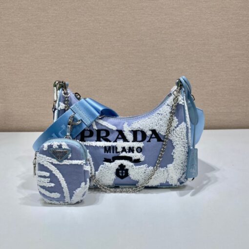 PRADA Re-Edition 2006 Embroidered Drill Shoulder Bag. Original Quality Bag including gift box, care book, dust bag, authenticity card. A new interpretation of an iconic Prada style, this Re-Edition 2005 bag features luxurious embroidery that creates a three-dimensional effect. Completed with a coordinated pouch that attaches to the shoulder strap, the bag can be worn in different ways thanks to the adjustable woven tape shoulder strap and chain handle. | CRIS&COCO Authentic Quality Designer Bags and Luxury Accessories