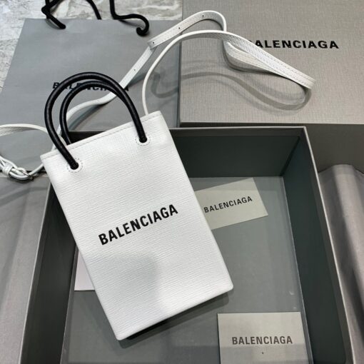 BALENCIAGA Mini Shopping Bag. Original Quality Bag including gift box, care book, dust bag, authenticity card. A new season may be here, but the frenzy for logomania is far from over. At the helm of the trend, Balenciaga continues to offer branded styles. Case in point: this mini shopping bag. Featuring round top handles, a shoulder strap, a strap closure, a main internal compartment and a printed logo to the front. | CRIS&COCO Authentic Quality Designer Bags and Luxury Accessories