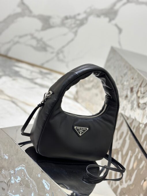 PRADA Soft Padded Mini Bag. Original Quality Bag including gift box, care book, dust bag, authenticity card. A harmonious, bold silhouette characterizes this mini-bag made of padded leather accented with the detachable, adjustable shoulder strap. Defined by its versatile allure, the accessory has a zipper closure and is decorated with the emblematic enameled metal triangle logo. | CRIS&COCO Authentic Quality Designer Bags and Luxury Accessories