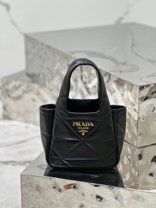 PRADA Nappa Tote Bag. High-End Quality Bag including gift box, care book, dust bag, authenticity card. An unusual triangle motif creates three-dimensional plays on this nappa-leather shopper bag, reinterpreting the iconic Prada shape. Defined by a versatile allure, the style is completed by a magnetic clasp and signature enameled-metal triangle logo. | CRIS AND COCO Authentic Quality Luxury Accessories