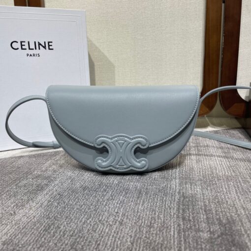 CELINE Besace Cuir Triomphe. High-End Quality Bag including gift box, care book, dust bag, authenticity card. Offered in the half-moon shape that’s all the rage now, the significantly wider format measures 23 cm from tip to tip. Each bag opens via a snap button closure to reveal a roomy interior compartment and a flat inner pocket. Another noticeable feature of the bag lies in the oversized Triomphe logo. With tonal stitching along the edges, the logo on the Triomphe Canvas comes in contrasting Tan leather. For a monochrome effect, go for the Ice Blue and Tan with logos in matching colours. | CRIS AND COCO Authentic Quality Luxury Accessories