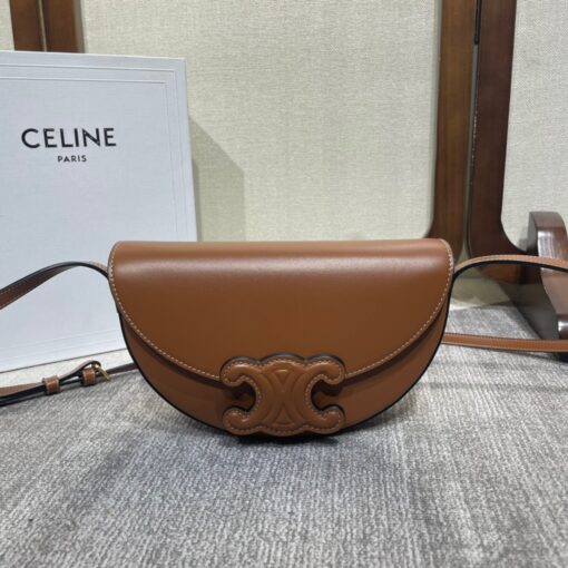 CELINE Besace Cuir Triomphe. High-End Quality Bag including gift box, care book, dust bag, authenticity card. Offered in the half-moon shape that’s all the rage now, the significantly wider format measures 23 cm from tip to tip. Each bag opens via a snap button closure to reveal a roomy interior compartment and a flat inner pocket. Another noticeable feature of the bag lies in the oversized Triomphe logo. With tonal stitching along the edges, the logo on the Triomphe Canvas comes in contrasting Tan leather. For a monochrome effect, go for the Ice Blue and Tan with logos in matching colours. | CRIS AND COCO Authentic Quality Luxury Accessories