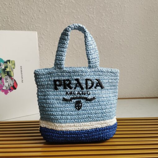 PRADA Small Crochet Tote Bag. Elevate Your Look with an Exquisite Tote Bag! This exquisite tote bag has a deconstructed design made of a light, natural material with a summery mood, raffia-effect yarn. Embroidered lettering logo decorates the front, and the emblematic triangle in enameled metal is the perfect finishing touch to the side. | CRIS&COCO Authentic Quality Designer Bags and Luxury Accessories