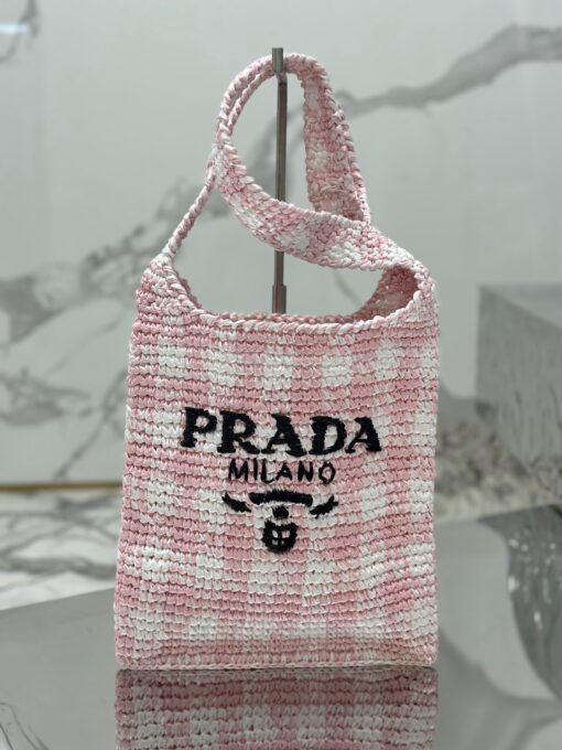 PRADA Crochet Bag- where refined logos meet natural raffia-inspired beauty.  Introducing a beautifully crafted tote bag, featuring a gentle, deconstructed design, elegantly crafted from raffia-effect yarn. This lightweight and natural material exudes a delightful summery vibe. The front adorns a sleek enameled metal triangle logo and delicately embroidered lettering logo, engaging in a captivating and harmonious aesthetic conversation. | CRIS&COCO Authentic Quality Designer Bags and Luxury Accessories
