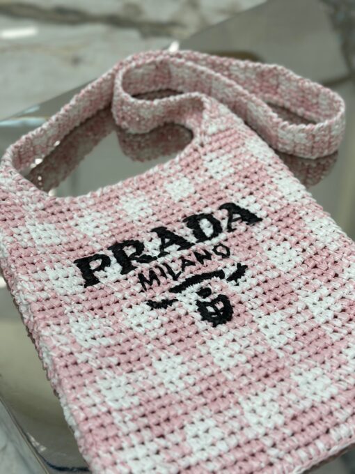PRADA Crochet Bag- where refined logos meet natural raffia-inspired beauty.  Introducing a beautifully crafted tote bag, featuring a gentle, deconstructed design, elegantly crafted from raffia-effect yarn. This lightweight and natural material exudes a delightful summery vibe. The front adorns a sleek enameled metal triangle logo and delicately embroidered lettering logo, engaging in a captivating and harmonious aesthetic conversation. | CRIS&COCO Authentic Quality Designer Bags and Luxury Accessories