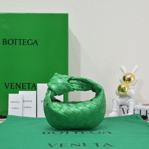 BOTTEGA VENETA Mini Jodie. Mini Marvel: Elevate Your Essentials. Introducing the BV Mini Jodie by Daniel Lee, a captivating embodiment of the mini bag trend infused with a captivating minimalist essence. True to the distinctive allure of the Jodie collection, this rendition showcases the iconic Intrecciato weave and the signature knot embellishment. Delicately compact, it effortlessly nestles under your arm akin to a charming baguette bag, yet offers ample space for your essentials such as your phone, cards, and keys. Despite its diminutive size, this mini bag radiates a vibrant aura through an array of lively hues, ensuring it leaves a memorable impression. | CRIS&COCO Authentic Quality Designer Bags and Luxury Accessories