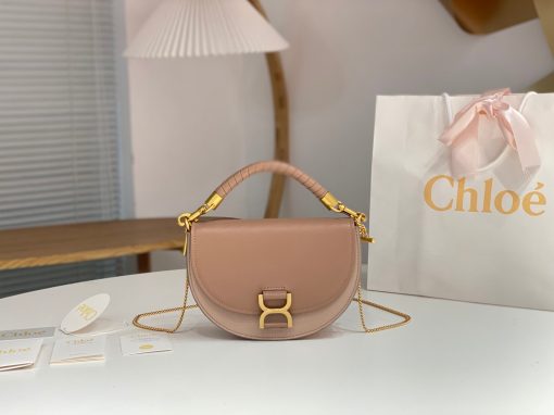 CHLOÉ Marcie Chain Flap Bag. Elevating Iconic Elegance: Marcie Line Redefined. Experience a fresh take on Chloé's iconic Marcie line with this exquisite chain flap bag, meticulously crafted from a captivating blend of nappa lambskin, grained calfskin, and sumptuous suede. The line's signature hardware undergoes a graceful transformation, now adorned with Chloé's engraved jewelry hallmark, adorning the flap with sophistication. An intricately hand-braided top handle pays homage to another hallmark Marcie feature, while a gracefully extended chain strap adds a refined touch. Whether you choose to drape it over your shoulder or wear it cross-body during the day, or opt to detach the strap and carry it by hand for a sophisticated evening ensemble, this flap bag is a versatile masterpiece. Chloé's Marcie bag line effortlessly melds a feminine aesthetic with the free-spirited vibe of the '70s. An equestrian-inspired allure takes center stage, elevated by the allure of gleaming gold-toned hardware, resulting in a distinctly feminine yet timelessly chic look.