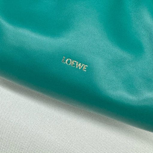 LOEWE Medium Flamenco Purse: Elegant Sophistication. Meet the Flamenco Purse – where timeless style meets modern elegance. Defined by its beautifully ruched design and signature side knots, this medium-sized bag is crafted from soft, supple nappa lambskin. It's the perfect blend of luxurious texture and sophisticated detailing, making it an essential accessory for any wardrobe.