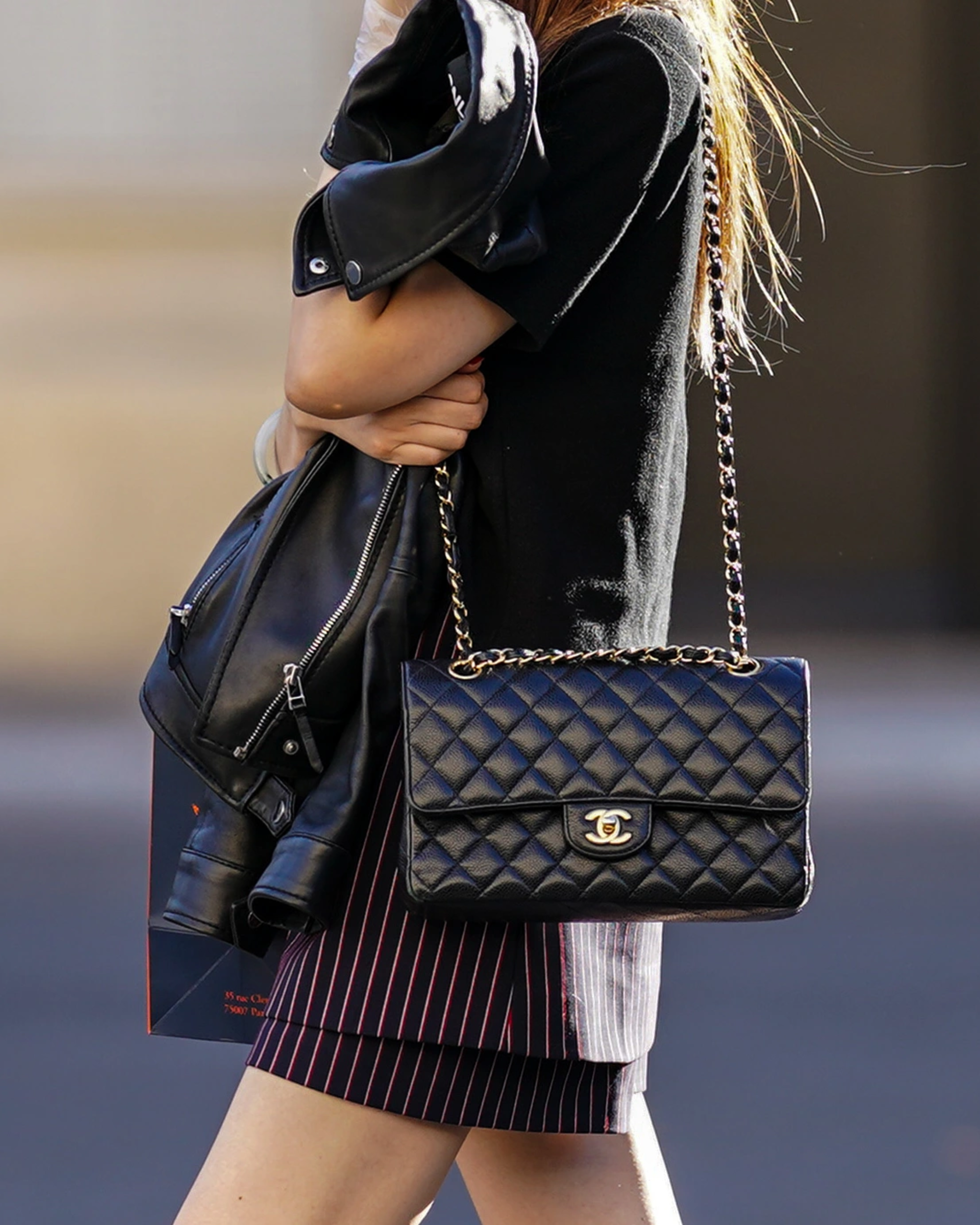 A close-up of a classic black Chanel flap bag with gold hardware, showcasing its iconic quilted design and elegant craftsmanship.