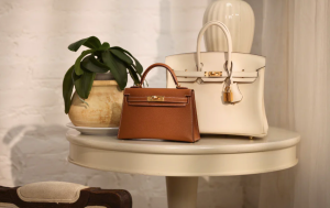 Two designer handbags on a leather chair.