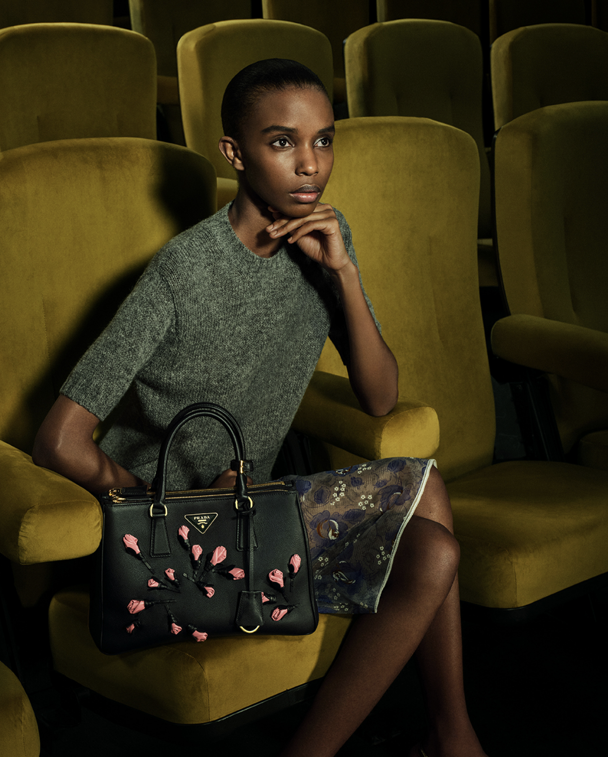 The PRADA Galleria Bag in black leather, spotlighted on a minimalist white shelf in a luxury boutique.