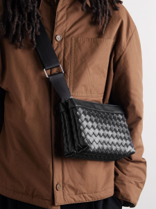 Close-up of a BOTTEGA VENETA messenger bag with signature Intrecciato weaving.