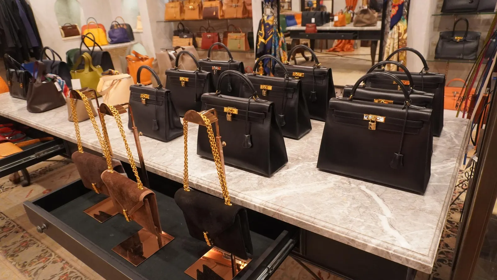 Rows of second-hand designer handbags, including LOUIS VUITTON and GUCCI, neatly displayed on shelves in a chic boutique.