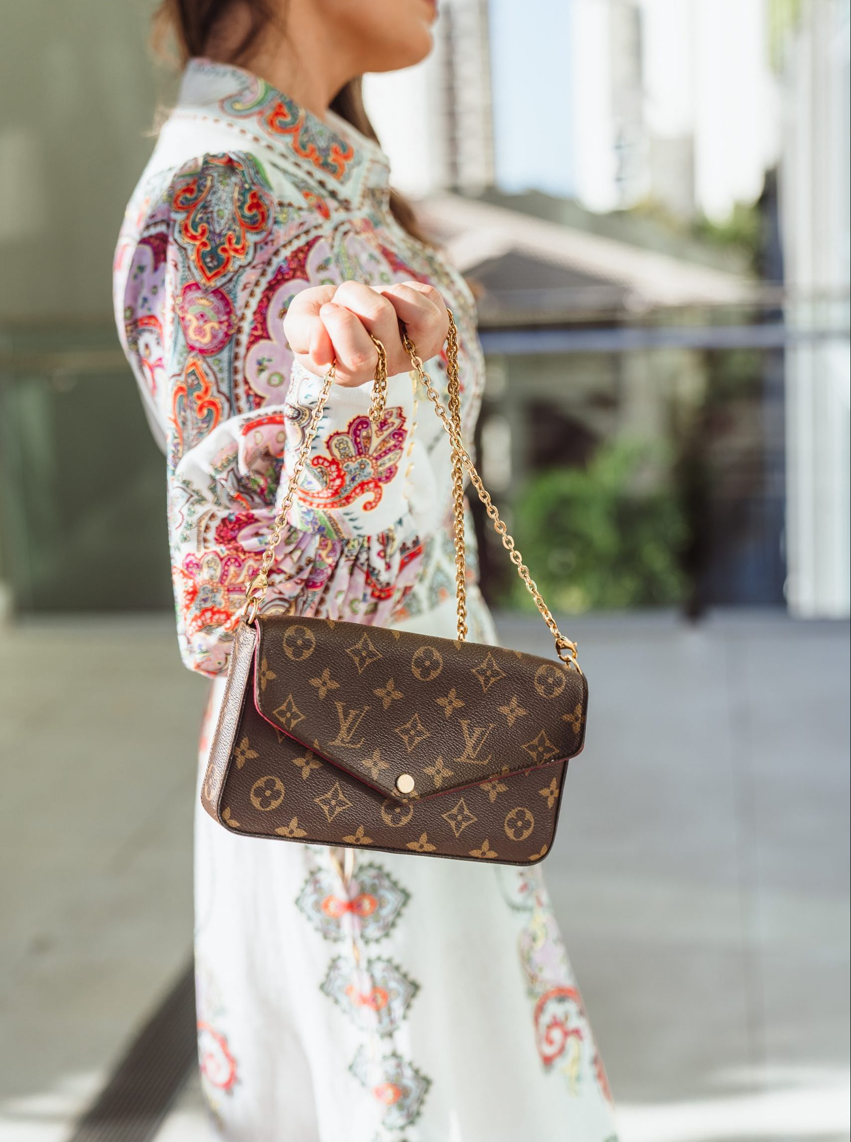 A LOUIS VUITTON Pochette Félicie in Monogram canvas, styled elegantly with a detachable gold chain.