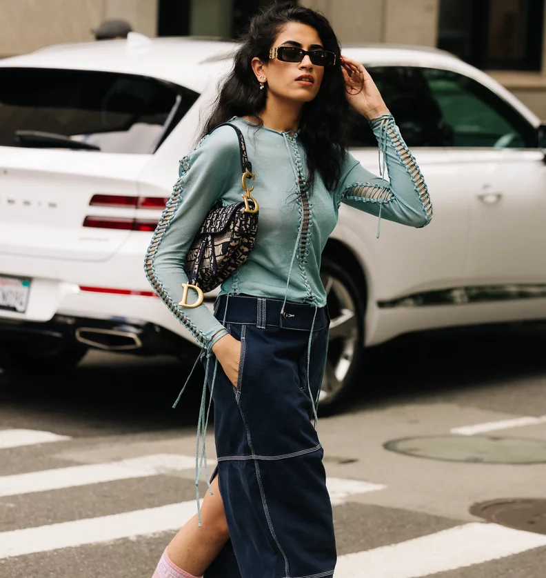 A fashion-forward woman confidently styling a designer-inspired bag with her outfit.