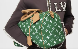 A celebrity walking down the street carrying a LOUIS VUITTON Speedy handbag.