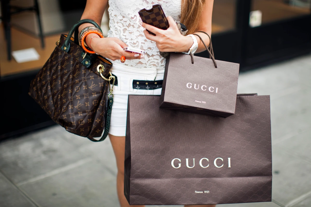 A shopper holding a luxury handbag with an eye-watering total.