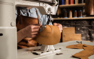 Close-up of a luxury-style handbag being assembled with precision tools