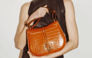 A fashionable woman flaunting a FENDI C'MON MINI replica bag with city skyscrapers in the background.
