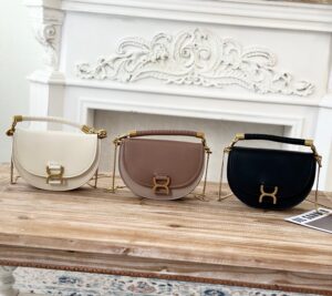 Marcie Chain Flap Bag. Authentic quality luxury bag crafted in genuine leather comes with authenticity card, dust bag and gift bag. Elevating Iconic Elegance: Marcie Line Redefined. Experience a fresh take on *loé's iconic Marcie line with this exquisite chain flap bag, meticulously crafted from a captivating blend of nappa lambskin, grained calfskin, and sumptuous suede. The line's signature hardware undergoes a graceful transformation, now adorned with *loé's engraved jewelry hallmark, adorning the flap with sophistication. An intricately hand-braided top handle pays homage to another hallmark Marcie feature, while a gracefully extended chain strap adds a refined touch. Whether you choose to drape it over your shoulder or wear it cross-body during the day, or opt to detach the strap and carry it by hand for a sophisticated evening ensemble, this flap bag is a versatile masterpiece. *loé's Marcie bag line effortlessly melds a feminine aesthetic with the free-spirited vibe of the '70s. An equestrian-inspired allure takes center stage, elevated by the allure of gleaming gold-toned hardware, resulting in a distinctly feminine yet timelessly chic look. - CRIS&COCO Marcie Chain Flap Bag. Authentic quality luxury bag crafted in genuine leather comes with authenticity card, dust bag and gift bag. Elevating Iconic Elegance: Marcie Line Redefined. Experience a fresh take on *loé's iconic Marcie line with this exquisite chain flap bag, meticulously crafted from a captivating blend of nappa lambskin, grained calfskin, and sumptuous suede. The line's signature hardware undergoes a graceful transformation, now adorned with *loé's engraved jewelry hallmark, adorning the flap with sophistication. An intricately hand-braided top handle pays homage to another hallmark Marcie feature, while a gracefully extended chain strap adds a refined touch. Whether you choose to drape it over your shoulder or wear it cross-body during the day, or opt to detach the strap and carry it by hand for a sophisticated evening ensemble, this flap bag is a versatile masterpiece. *loé's Marcie bag line effortlessly melds a feminine aesthetic with the free-spirited vibe of the '70s. An equestrian-inspired allure takes center stage, elevated by the allure of gleaming gold-toned hardware, resulting in a distinctly feminine yet timelessly chic look.