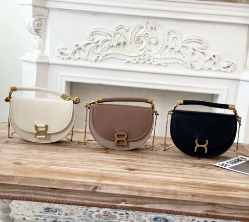 Marcie Chain Flap Bag. Authentic quality luxury bag crafted in genuine leather comes with authenticity card, dust bag and gift bag. Elevating Iconic Elegance: Marcie Line Redefined. Experience a fresh take on *loé's iconic Marcie line with this exquisite chain flap bag, meticulously crafted from a captivating blend of nappa lambskin, grained calfskin, and sumptuous suede. The line's signature hardware undergoes a graceful transformation, now adorned with *loé's engraved jewelry hallmark, adorning the flap with sophistication. An intricately hand-braided top handle pays homage to another hallmark Marcie feature, while a gracefully extended chain strap adds a refined touch. Whether you choose to drape it over your shoulder or wear it cross-body during the day, or opt to detach the strap and carry it by hand for a sophisticated evening ensemble, this flap bag is a versatile masterpiece. *loé's Marcie bag line effortlessly melds a feminine aesthetic with the free-spirited vibe of the '70s. An equestrian-inspired allure takes center stage, elevated by the allure of gleaming gold-toned hardware, resulting in a distinctly feminine yet timelessly chic look.