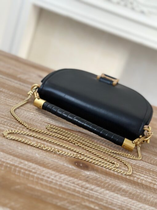 Marcie Chain Flap Bag. Authentic quality luxury bag crafted in genuine leather comes with authenticity card, dust bag and gift bag. Elevating Iconic Elegance: Marcie Line Redefined. Experience a fresh take on *loé's iconic Marcie line with this exquisite chain flap bag, meticulously crafted from a captivating blend of nappa lambskin, grained calfskin, and sumptuous suede. The line's signature hardware undergoes a graceful transformation, now adorned with *loé's engraved jewelry hallmark, adorning the flap with sophistication. An intricately hand-braided top handle pays homage to another hallmark Marcie feature, while a gracefully extended chain strap adds a refined touch. Whether you choose to drape it over your shoulder or wear it cross-body during the day, or opt to detach the strap and carry it by hand for a sophisticated evening ensemble, this flap bag is a versatile masterpiece. *loé's Marcie bag line effortlessly melds a feminine aesthetic with the free-spirited vibe of the '70s. An equestrian-inspired allure takes center stage, elevated by the allure of gleaming gold-toned hardware, resulting in a distinctly feminine yet timelessly chic look.