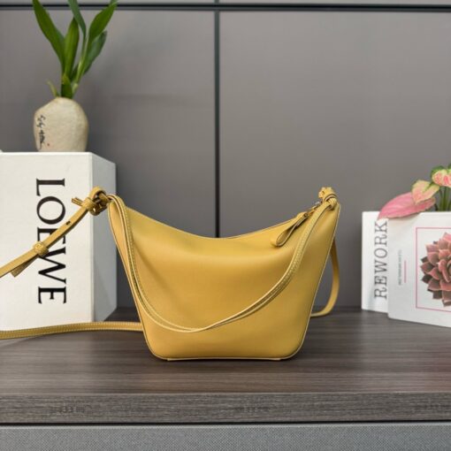 Mini Hammock Hobo. Authentic quality luxury bag crafted in genuine leather comes with authenticity card, dust bag and gift bag. Effortless Form, Everyday Function.  The Mini Hammock Hobo is a contemporary reimagining of Loewe’s iconic Hammock bag. This streamlined variation offers a sleek, sculptural silhouette designed as a versatile sling bag for modern living. Expertly crafted in classic calfskin, it features soft, supple leather and a compact form that adapts effortlessly to your day. The unique design allows for multiple carry options—wear it crossbody, over the shoulder, or by hand. Elegant yet functional, this mini hobo is perfect for essentials, making it an ideal choice for both daily wear and minimalist style statements.