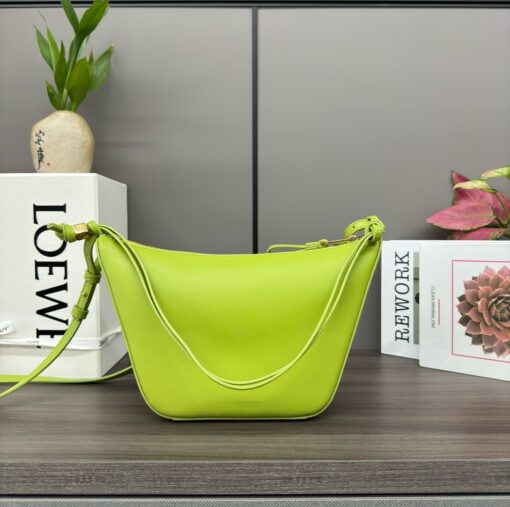 Mini Hammock Hobo. Authentic quality luxury bag crafted in genuine leather comes with authenticity card, dust bag and gift bag. Effortless Form, Everyday Function.  The Mini Hammock Hobo is a contemporary reimagining of Loewe’s iconic Hammock bag. This streamlined variation offers a sleek, sculptural silhouette designed as a versatile sling bag for modern living. Expertly crafted in classic calfskin, it features soft, supple leather and a compact form that adapts effortlessly to your day. The unique design allows for multiple carry options—wear it crossbody, over the shoulder, or by hand. Elegant yet functional, this mini hobo is perfect for essentials, making it an ideal choice for both daily wear and minimalist style statements.