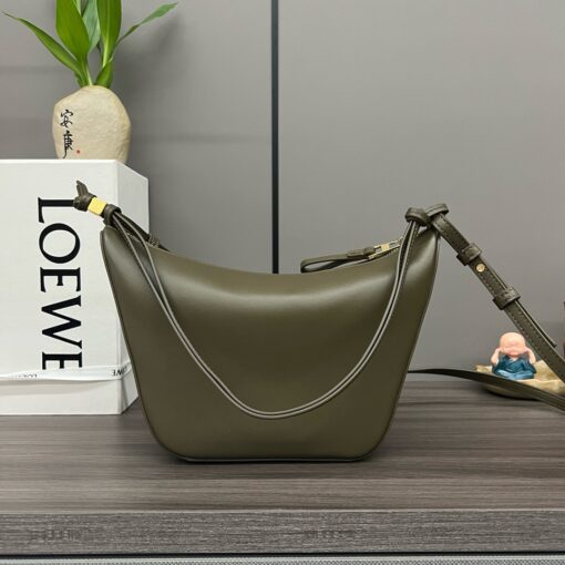 Mini Hammock Hobo. Authentic quality luxury bag crafted in genuine leather comes with authenticity card, dust bag and gift bag. Effortless Form, Everyday Function.  The Mini Hammock Hobo is a contemporary reimagining of Loewe’s iconic Hammock bag. This streamlined variation offers a sleek, sculptural silhouette designed as a versatile sling bag for modern living. Expertly crafted in classic calfskin, it features soft, supple leather and a compact form that adapts effortlessly to your day. The unique design allows for multiple carry options—wear it crossbody, over the shoulder, or by hand. Elegant yet functional, this mini hobo is perfect for essentials, making it an ideal choice for both daily wear and minimalist style statements.