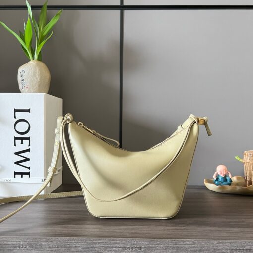 Mini Hammock Hobo. Authentic quality luxury bag crafted in genuine leather comes with authenticity card, dust bag and gift bag. Effortless Form, Everyday Function.  The Mini Hammock Hobo is a contemporary reimagining of Loewe’s iconic Hammock bag. This streamlined variation offers a sleek, sculptural silhouette designed as a versatile sling bag for modern living. Expertly crafted in classic calfskin, it features soft, supple leather and a compact form that adapts effortlessly to your day. The unique design allows for multiple carry options—wear it crossbody, over the shoulder, or by hand. Elegant yet functional, this mini hobo is perfect for essentials, making it an ideal choice for both daily wear and minimalist style statements.