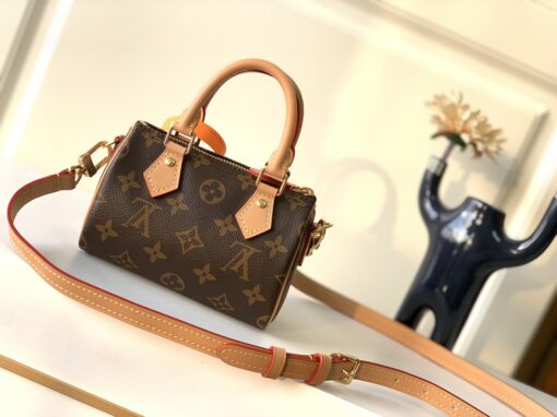 Speedy Nano. Authentic quality luxury bag crafted in genuine leather comes with authenticity card, dust bag and gift bag. Iconic Style, Perfectly Miniaturized. Meet the LV Speedy Nano — a petite powerhouse that captures the timeless allure of the iconic Speedy in its most charming form. Revamped in classic Monogram canvas and finished with aged natural cowhide leather, this mini marvel is made for the modern minimalist. Crafted with delicate gold-tone hardware and featuring two signature top handles, the Speedy Nano is both playful and practical. Its removable, adjustable shoulder strap adds effortless versatility—carry it by hand for polished poise or sling it crossbody for chic, on-the-go ease. Compact enough for your essentials. Iconic enough to turn heads. Small bag, big legacy!