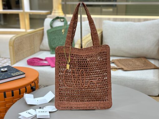 Summer Banana Tote Bag. Authentic quality luxury bag crafted in genuine leather comes with authenticity card, dust bag and gift bag. Heritage in Hand: Where Artisan Craft Meets Summer Elegance. Introducing the Summer Banana Tote—an artisanal masterpiece crafted from raffia and calfskin by a single artisan over 4.5 days in partnership with Made For A Woman. This spacious tote is adorned with a handwritten signature inspired by *loé’s rich heritage, while a playful dangling chain and delicate charms add the perfect finishing touch. A celebration of craftsmanship and effortless summer style.