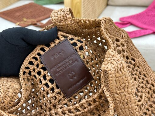 Summer Banana Tote Bag. Authentic quality luxury bag crafted in genuine leather comes with authenticity card, dust bag and gift bag. Heritage in Hand: Where Artisan Craft Meets Summer Elegance. Introducing the Summer Banana Tote—an artisanal masterpiece crafted from raffia and calfskin by a single artisan over 4.5 days in partnership with Made For A Woman. This spacious tote is adorned with a handwritten signature inspired by *loé’s rich heritage, while a playful dangling chain and delicate charms add the perfect finishing touch. A celebration of craftsmanship and effortless summer style.