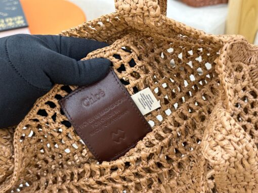 Summer Banana Tote Bag. Authentic quality luxury bag crafted in genuine leather comes with authenticity card, dust bag and gift bag. Heritage in Hand: Where Artisan Craft Meets Summer Elegance. Introducing the Summer Banana Tote—an artisanal masterpiece crafted from raffia and calfskin by a single artisan over 4.5 days in partnership with Made For A Woman. This spacious tote is adorned with a handwritten signature inspired by *loé’s rich heritage, while a playful dangling chain and delicate charms add the perfect finishing touch. A celebration of craftsmanship and effortless summer style.