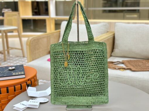 Summer Banana Tote Bag. Authentic quality luxury bag crafted in genuine leather comes with authenticity card, dust bag and gift bag. Heritage in Hand: Where Artisan Craft Meets Summer Elegance. Introducing the Summer Banana Tote—an artisanal masterpiece crafted from raffia and calfskin by a single artisan over 4.5 days in partnership with Made For A Woman. This spacious tote is adorned with a handwritten signature inspired by *loé’s rich heritage, while a playful dangling chain and delicate charms add the perfect finishing touch. A celebration of craftsmanship and effortless summer style.