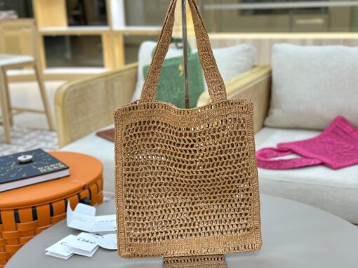 Summer Banana Tote Bag. Authentic quality luxury bag crafted in genuine leather comes with authenticity card, dust bag and gift bag. Heritage in Hand: Where Artisan Craft Meets Summer Elegance. Introducing the Summer Banana Tote—an artisanal masterpiece crafted from raffia and calfskin by a single artisan over 4.5 days in partnership with Made For A Woman. This spacious tote is adorned with a handwritten signature inspired by *loé’s rich heritage, while a playful dangling chain and delicate charms add the perfect finishing touch. A celebration of craftsmanship and effortless summer style.