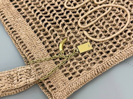 Summer Banana Tote Bag. Authentic quality luxury bag crafted in genuine leather comes with authenticity card, dust bag and gift bag. Heritage in Hand: Where Artisan Craft Meets Summer Elegance. Introducing the Summer Banana Tote—an artisanal masterpiece crafted from raffia and calfskin by a single artisan over 4.5 days in partnership with Made For A Woman. This spacious tote is adorned with a handwritten signature inspired by *loé’s rich heritage, while a playful dangling chain and delicate charms add the perfect finishing touch. A celebration of craftsmanship and effortless summer style.